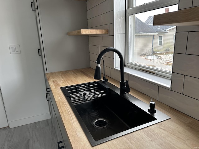 kitchen featuring light wood-type flooring, butcher block counters, and sink