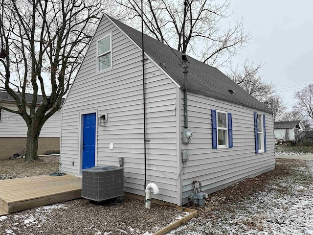 snow covered property with cooling unit and a deck