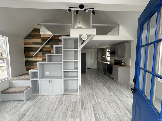 kitchen with stainless steel range with electric cooktop, sink, range hood, tasteful backsplash, and light hardwood / wood-style floors