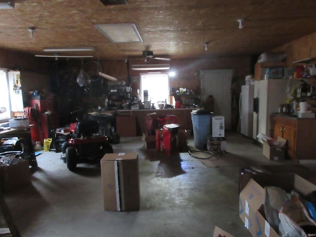 garage featuring a workshop area, ceiling fan, and white fridge