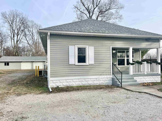 view of front facade featuring an outdoor structure, a porch, and a garage