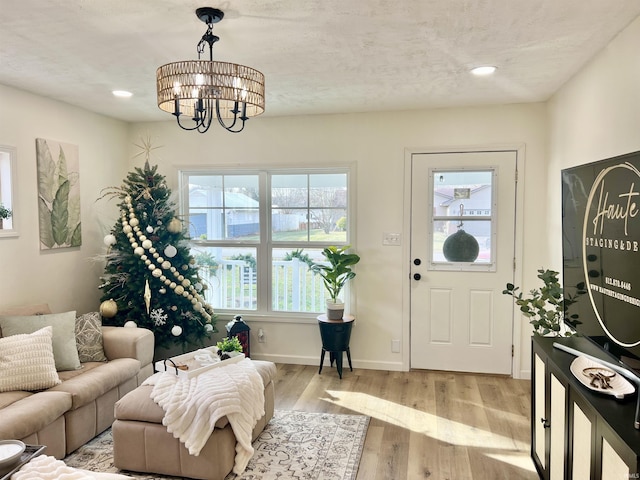 foyer featuring a textured ceiling, light hardwood / wood-style floors, and a notable chandelier