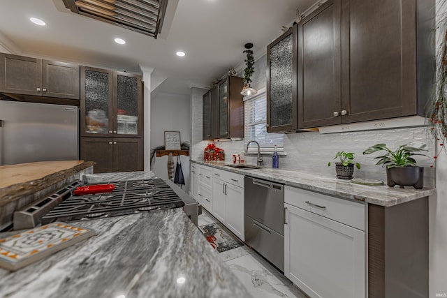 kitchen with white cabinetry, sink, light stone countertops, backsplash, and appliances with stainless steel finishes