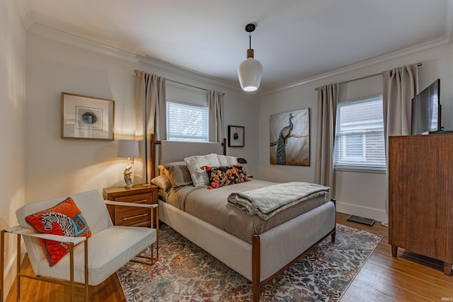 bedroom featuring wood-type flooring and ornamental molding