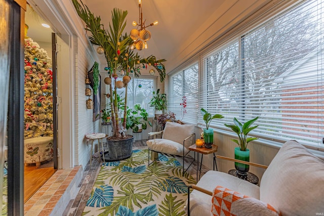 sunroom / solarium with a chandelier and vaulted ceiling