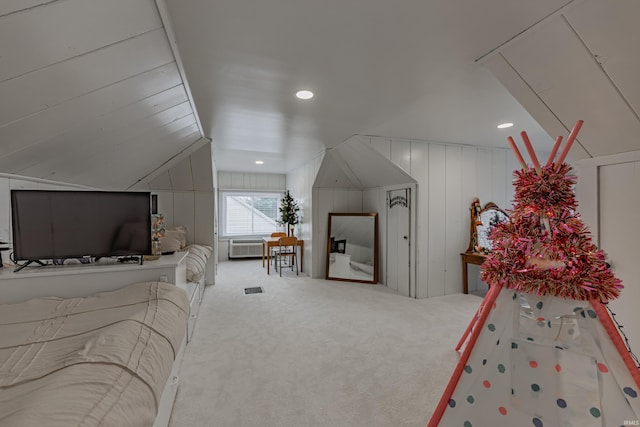 carpeted bedroom with vaulted ceiling and wooden walls