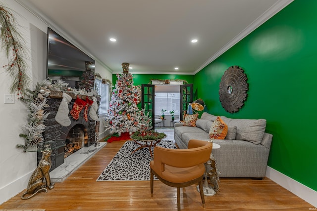 living room with crown molding, hardwood / wood-style floors, and a premium fireplace