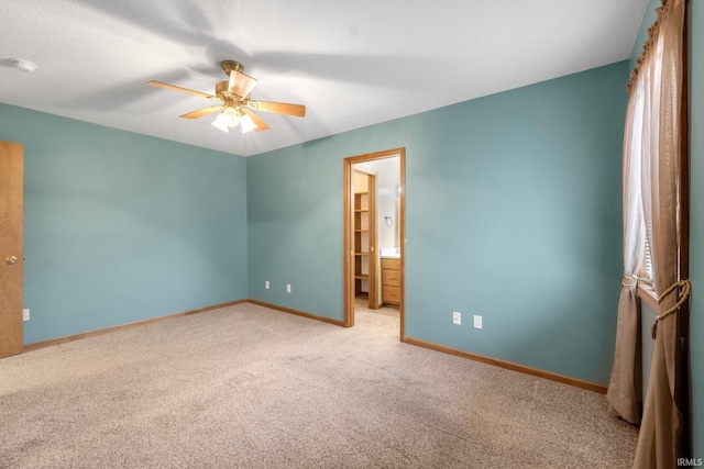 unfurnished bedroom featuring ceiling fan, light carpet, and ensuite bath