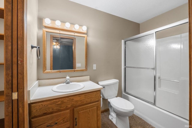 full bathroom with vanity, bath / shower combo with glass door, and toilet