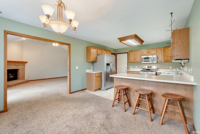 kitchen with light colored carpet, stainless steel appliances, a breakfast bar area, and a chandelier