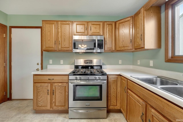 kitchen featuring sink, light tile patterned flooring, and appliances with stainless steel finishes