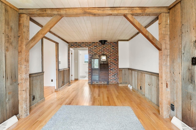 unfurnished living room with light hardwood / wood-style floors, wood walls, and wood ceiling