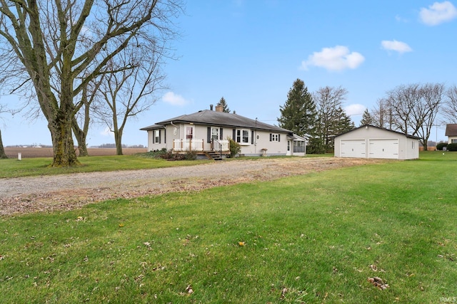 view of front of property featuring an outbuilding, a front yard, and a garage