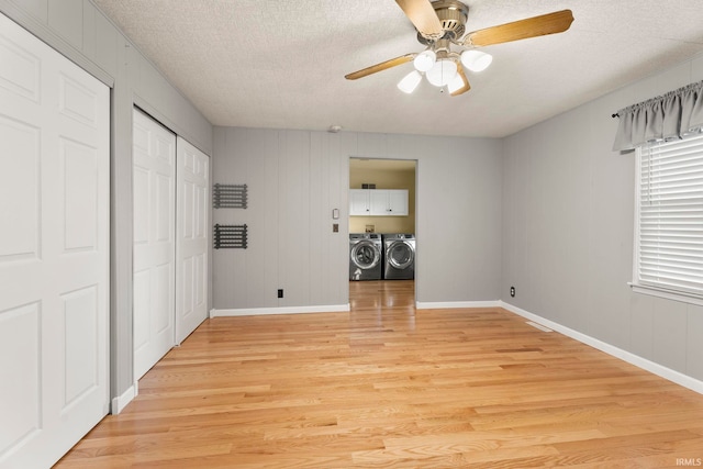 unfurnished bedroom featuring washer and dryer, ceiling fan, light wood-type flooring, and a textured ceiling