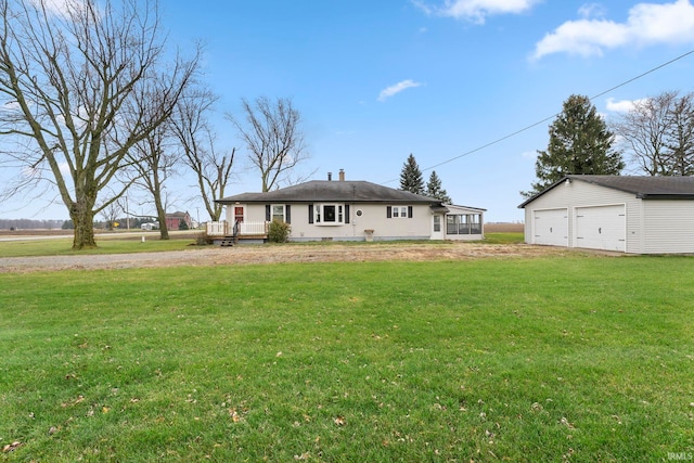 back of house with a sunroom, covered porch, an outbuilding, a yard, and a garage