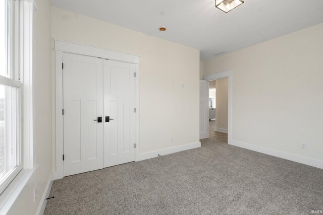 unfurnished bedroom featuring carpet flooring and a closet