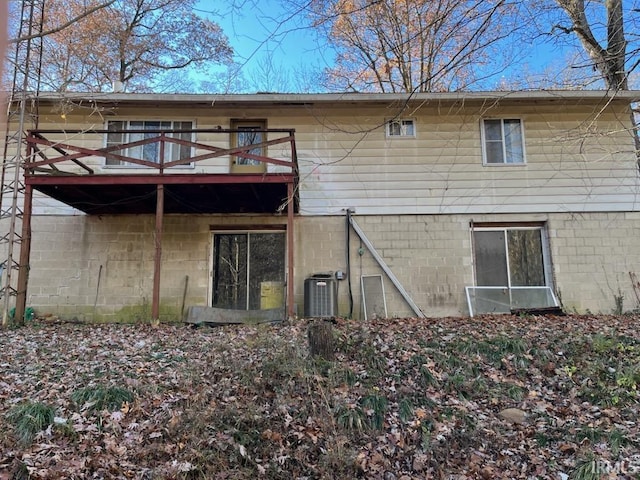 rear view of property featuring a balcony and central AC unit