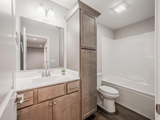 full bathroom with hardwood / wood-style floors, vanity, shower / bathtub combination, and toilet