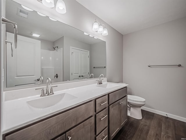 bathroom with a shower, wood-type flooring, vanity, and toilet