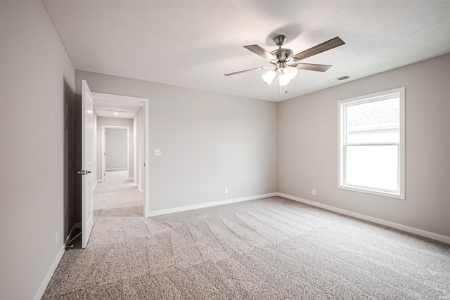 carpeted spare room featuring ceiling fan