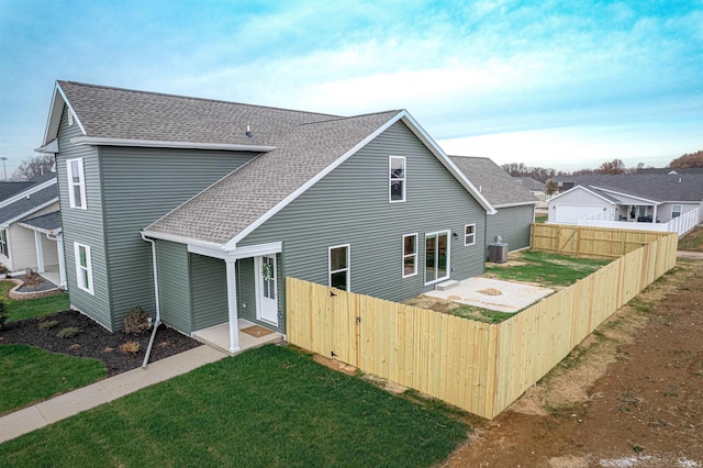 back of house featuring a yard and cooling unit