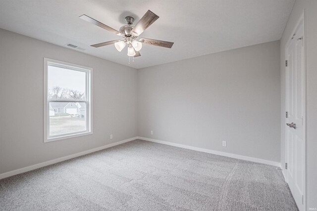 carpeted spare room featuring ceiling fan