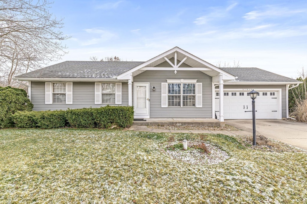 ranch-style house featuring a garage and a front lawn