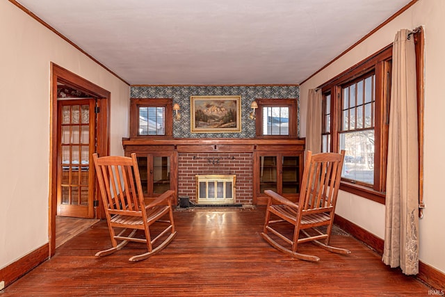 sitting room with hardwood / wood-style flooring, crown molding, and a fireplace