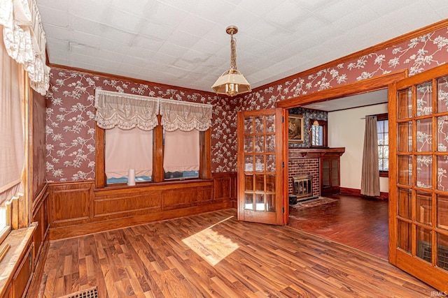 spare room with a fireplace, hardwood / wood-style floors, and ornamental molding