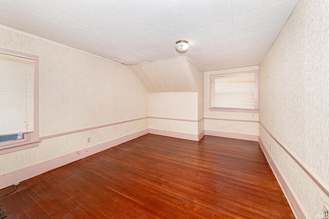 additional living space featuring dark hardwood / wood-style floors and vaulted ceiling