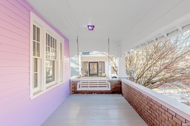 snow covered patio featuring covered porch