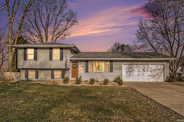 tri-level home with a yard and a garage