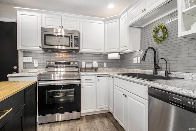 kitchen featuring white cabinets, appliances with stainless steel finishes, hardwood / wood-style floors, and sink