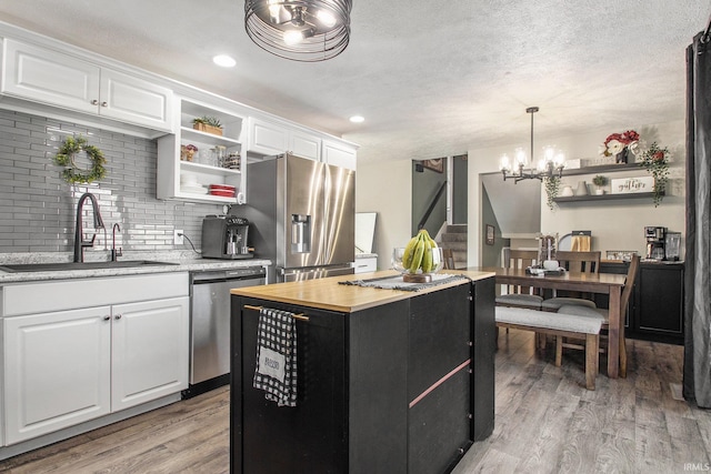 kitchen featuring white cabinets, a center island, sink, and appliances with stainless steel finishes