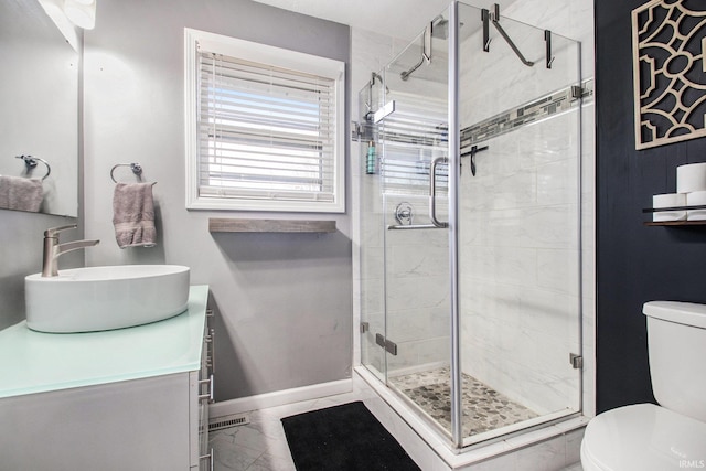 bathroom with vanity, toilet, and a shower with shower door