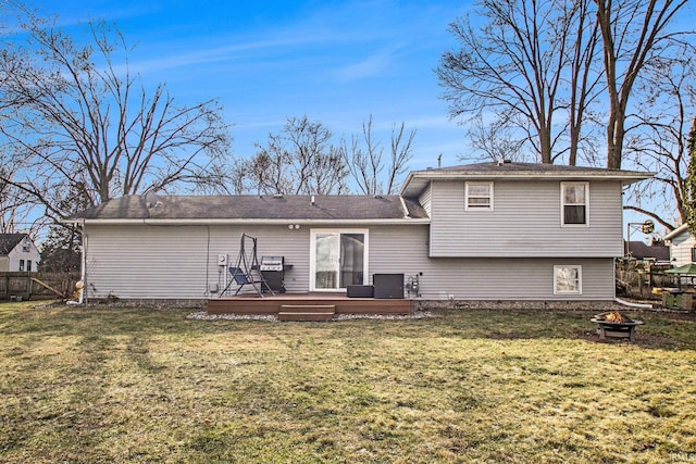 back of house featuring central air condition unit, a lawn, an outdoor fire pit, and a wooden deck