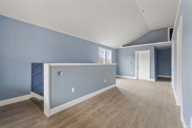 spare room featuring hardwood / wood-style floors and lofted ceiling