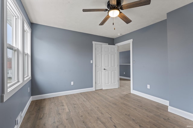 unfurnished room featuring ceiling fan, plenty of natural light, and hardwood / wood-style flooring