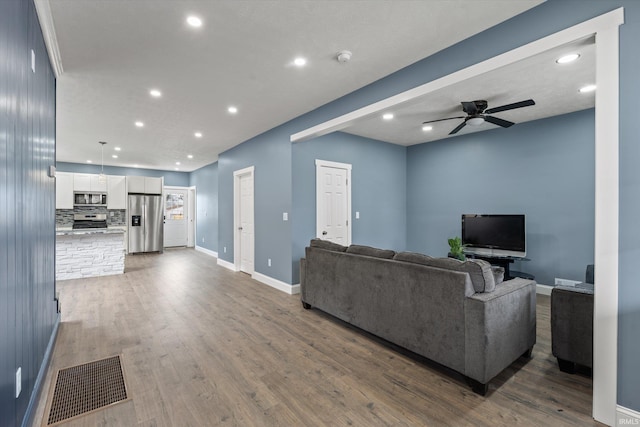 living room with ceiling fan and dark hardwood / wood-style flooring