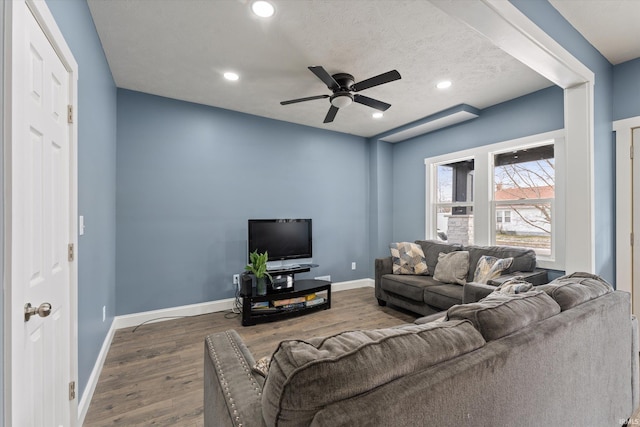 living room featuring ceiling fan, dark hardwood / wood-style flooring, and a textured ceiling