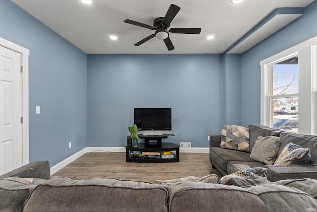 living room with ceiling fan, hardwood / wood-style floors, and a textured ceiling