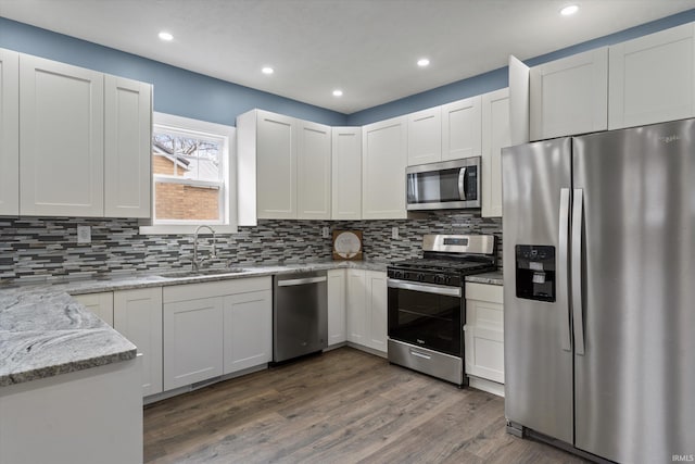 kitchen with sink, white cabinetry, stainless steel appliances, and dark wood-type flooring