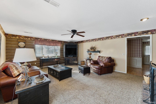 carpeted living room with a textured ceiling, ceiling fan, and wood walls