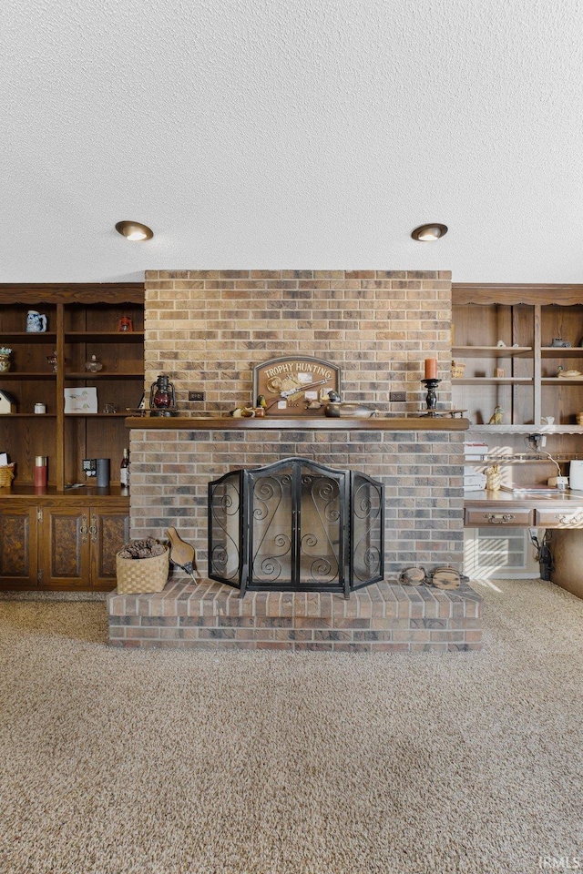 unfurnished living room with a fireplace, built in features, carpet floors, and a textured ceiling