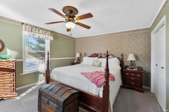 carpeted bedroom with a closet, crown molding, and ceiling fan