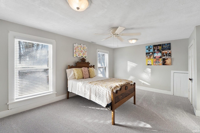 bedroom featuring ceiling fan, carpet floors, and a textured ceiling