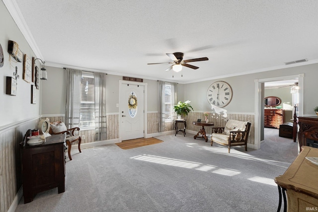 sitting room featuring crown molding, a textured ceiling, and a wealth of natural light