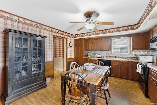 kitchen featuring black appliances, crown molding, sink, ceiling fan, and light wood-type flooring