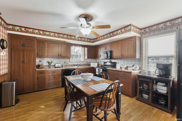 kitchen featuring ceiling fan, light hardwood / wood-style floors, plenty of natural light, and black appliances