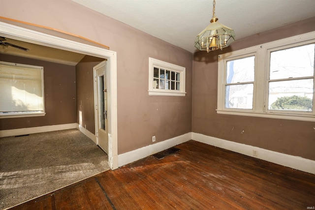 unfurnished room with dark hardwood / wood-style flooring and ceiling fan with notable chandelier